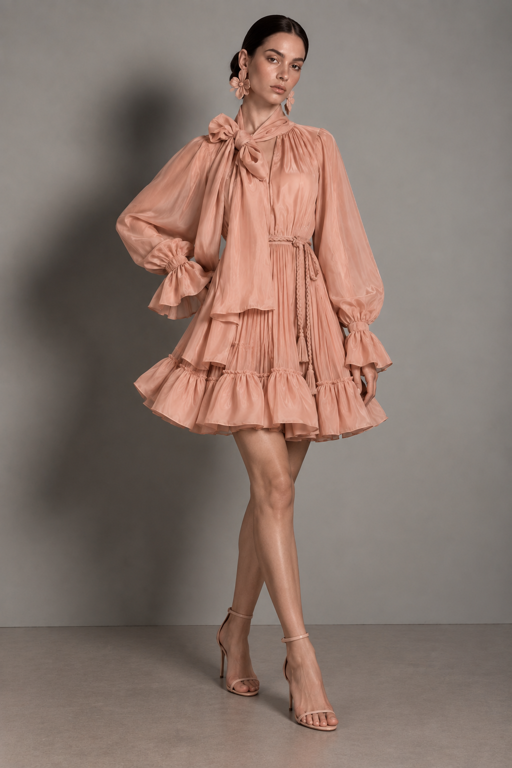 Dusty rose mini dress with a gathered high-neck bodice, an oversized neck bow, blouson sleeves, and a tiered ruffled hem.