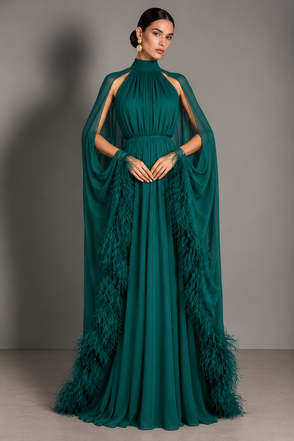 Emerald halter gown with cut-out shoulders and long feather-tipped cape streamers falling to the floor.