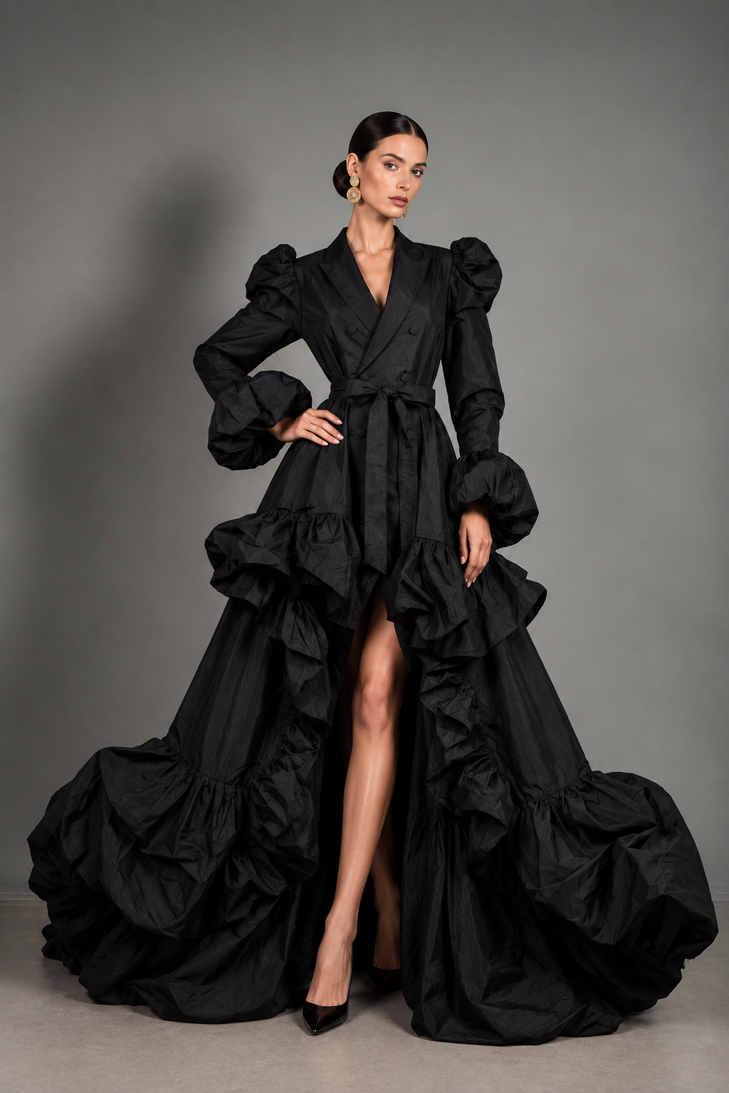 Black double-breasted, structured-lapel coat-dress with puffed leg-o-mutton sleeves, a self-tie sash, and a dramatic ruffled high-low train.